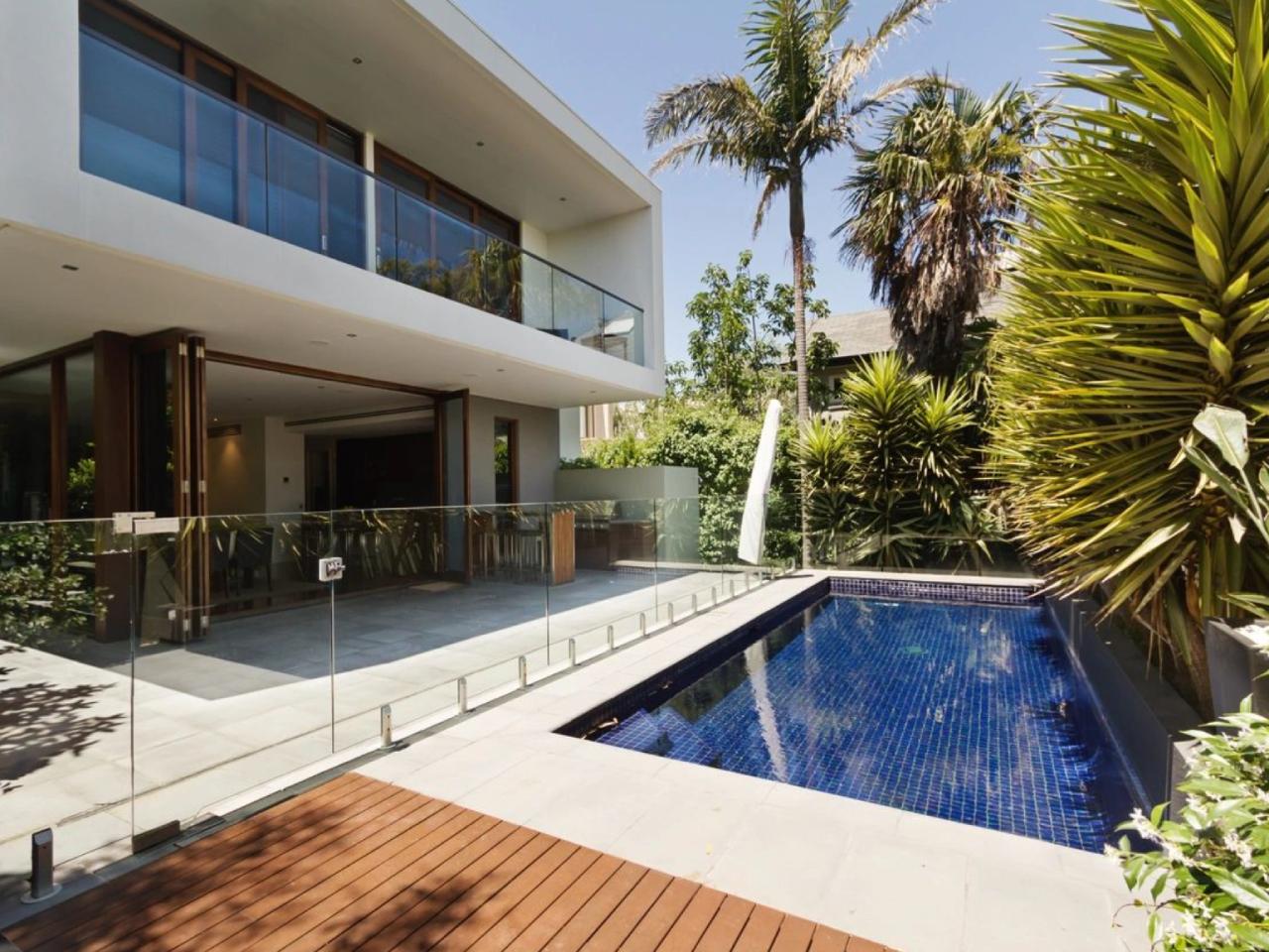 Clean, freshly serviced backyard pool with clear blue water and tidy deck