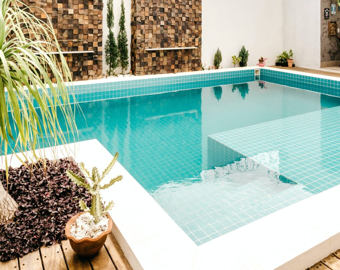 Turquoise tiled backyard pool with clean waterline and steps